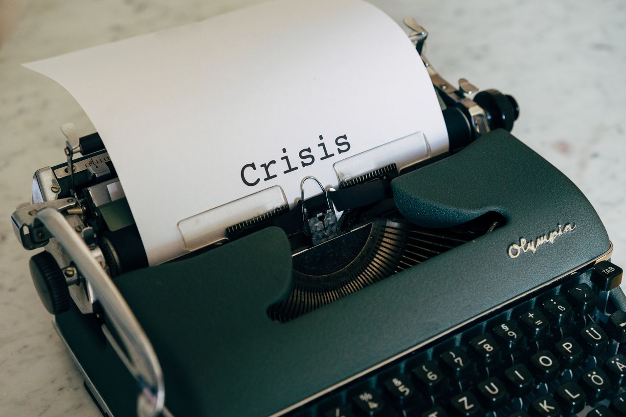 services-02 Close-up of a vintage typewriter with the word Crisis typed on paper.