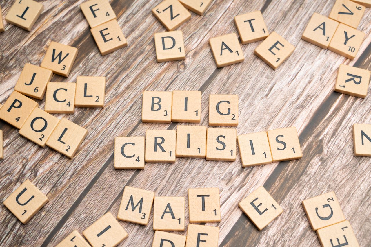 services-04 Wooden tiles forming the words Big Crisis on a wooden background.